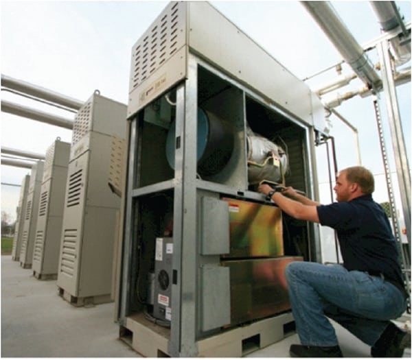 A 65-kW Capstone C65 microturbine equipped with integrated heat recovery is inspected by a technician