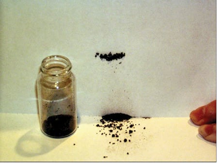 4. Attractive nuisance. A magnet behind a piece of white paper demonstrates the magnetic properties of the insoluble residue identified as magnetite (Fe3O4). Courtesy: Analysts Inc.â€©