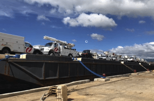 Figure 2 - Trucks and other equipment for use by Xcel Energy workers in Puerto Rico are loaded onto a barge in Lake Charles, Louisiana, in January. The equipment, along with workers from Xcel, is being deployed to help restore power on the island. Courtesy: Xcel Energy 