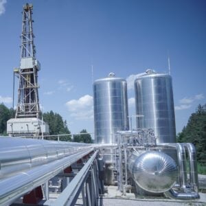 Surface facilities at Eavor’s Geretsried closed-loop geothermal project in Bavaria, Germany, including the Organic Rankine Cycle (ORC) power plant equipment, working-fluid storage tanks, and associated piping infrastructure adjacent to one of the site’s drilling rigs. The installation anchors the world’s first commercial deployment of Eavor’s multilateral Eavor-Loop well system, which generates electricity and district heat without fluid exchange with subsurface formations. Courtesy: Luckypage / Ekkehard Winkler.