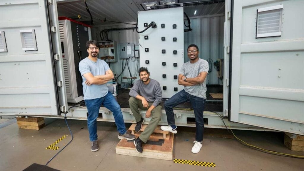 Three NC State researchers stand in front of the megawatt-class solid-state transformer developed for field testing on a utility distribution feeder.